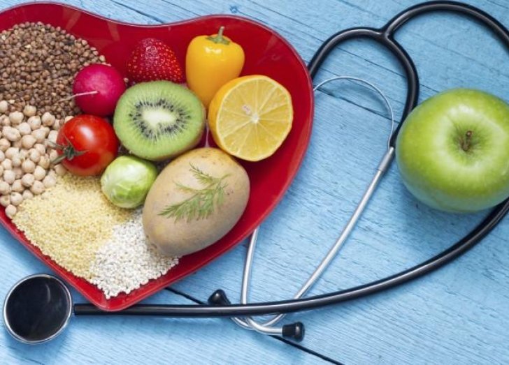 Fruits and vegetables and stethoscope pictured. 