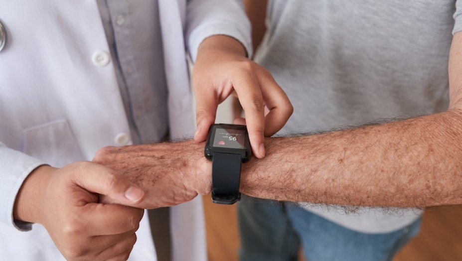 A doctor looks at a patient's watch. 