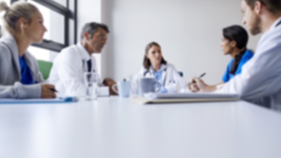 A group of physicians having a discussion at a conference table. 